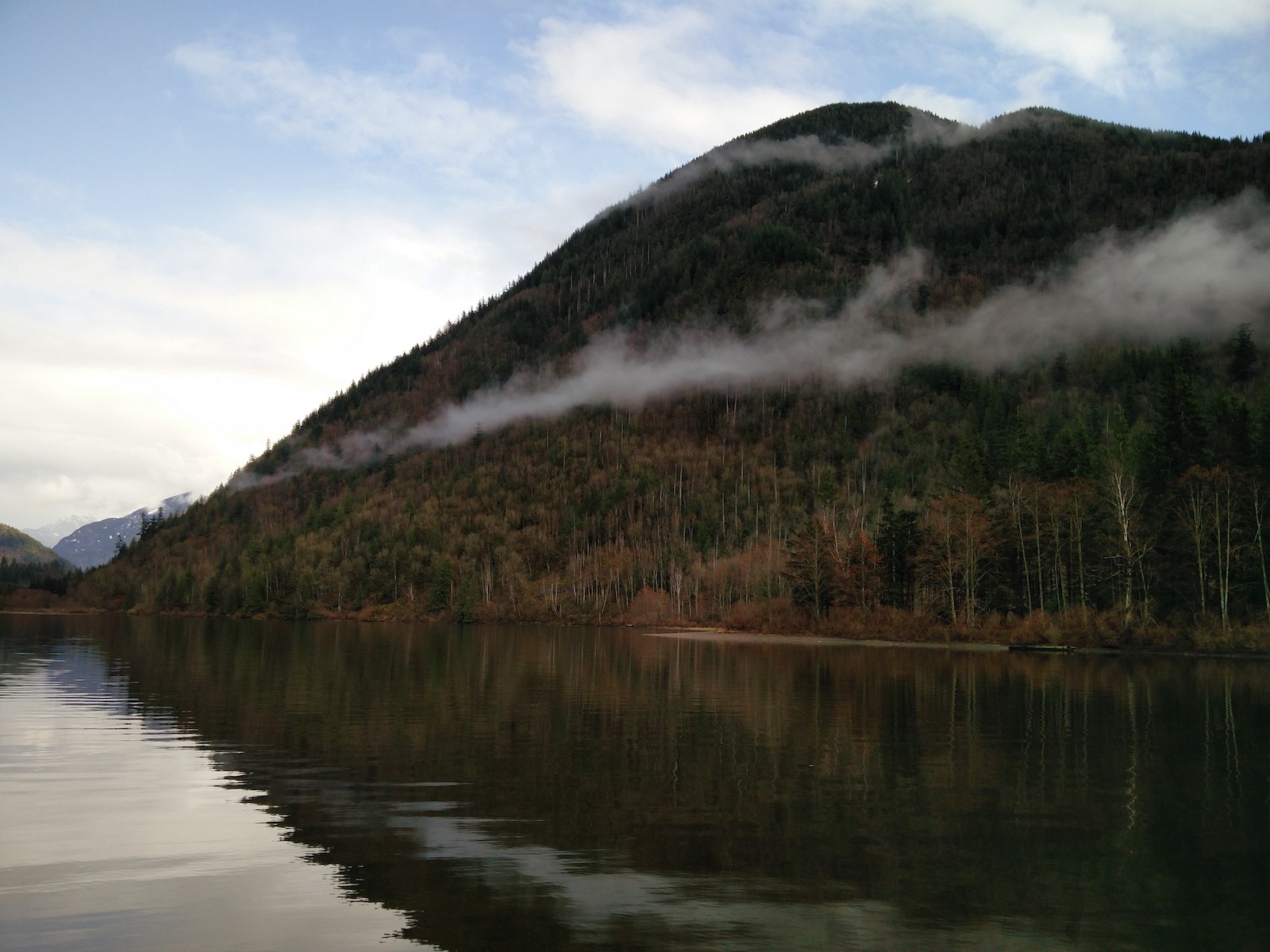 Point de vue sur le lac côté droit ou la colinne bordant l'eau mêle des arbres verts et oranges.